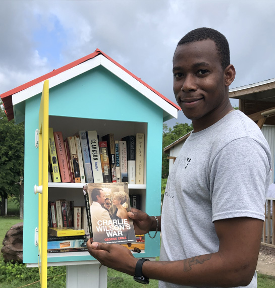 A man smiling while holding a book.