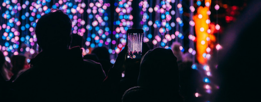 People looking at Christmas Lights and taking a video of the lights on an iPhone