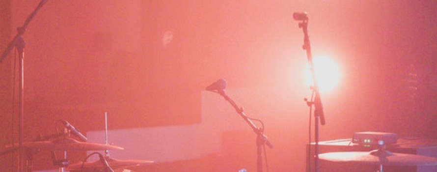 concert stage filled with equipment under hazy red light