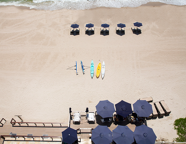 over-looking view of umbrellas and beach chairs along the water