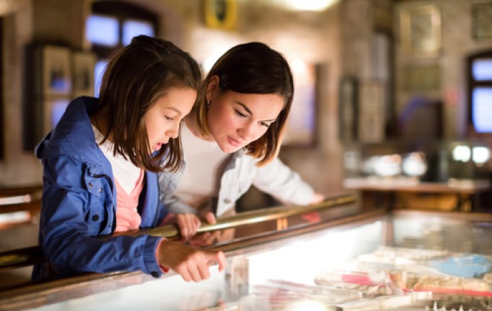 mother and daughter looking into glass case at museum