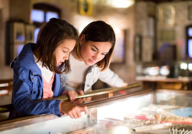 mother and daughter looking into glass case at museum