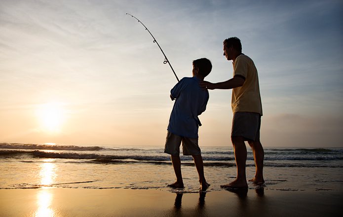 Man and boy fishing on the beach