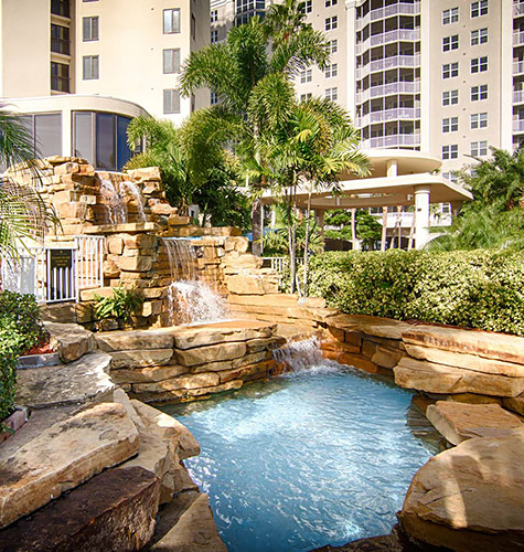 waterfalls in front of a pool with white sky lines