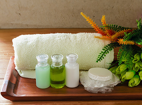 towel with soaps and lotions on a wooden tray