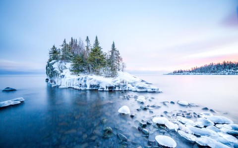 small island in the middle of the lake on a snowy day