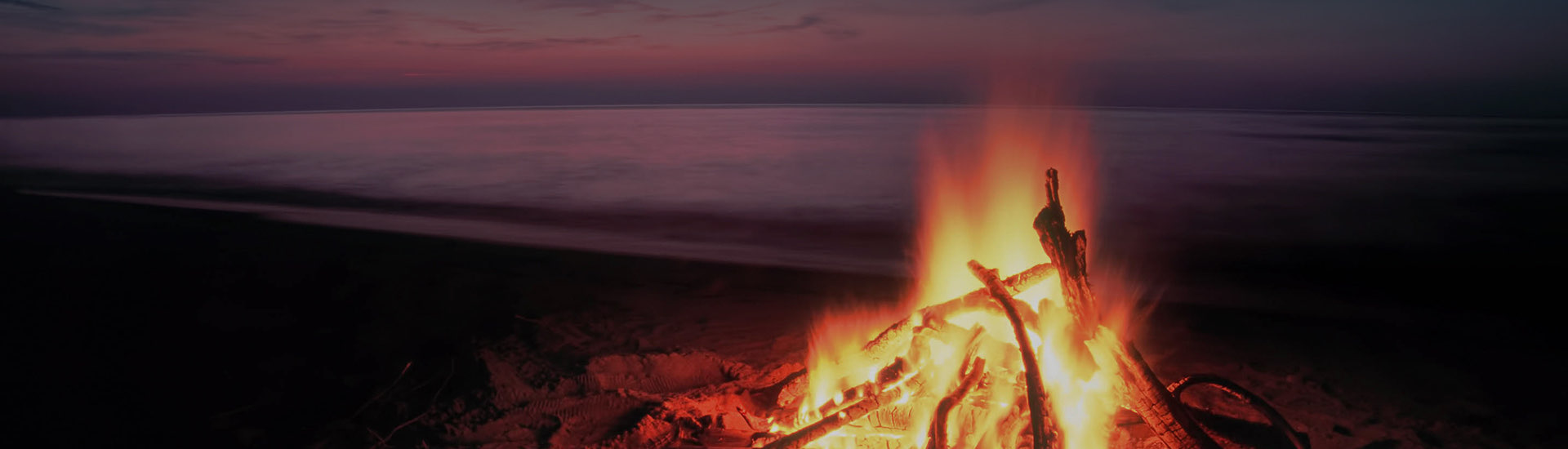 bonfire on the lakeshore at sunset