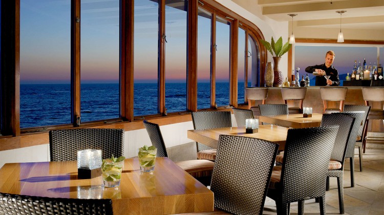 dining area with a bar overlooking the ocean