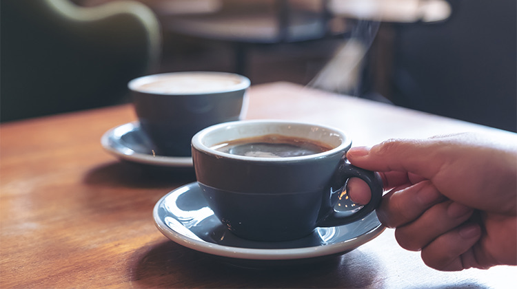 two cups of hot coffee on a wooden table