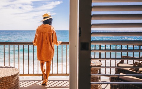 woman looking at the ocean from her balcony