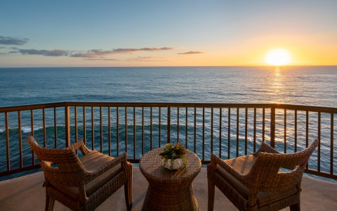 balcony with two chairs overlooking the ocean