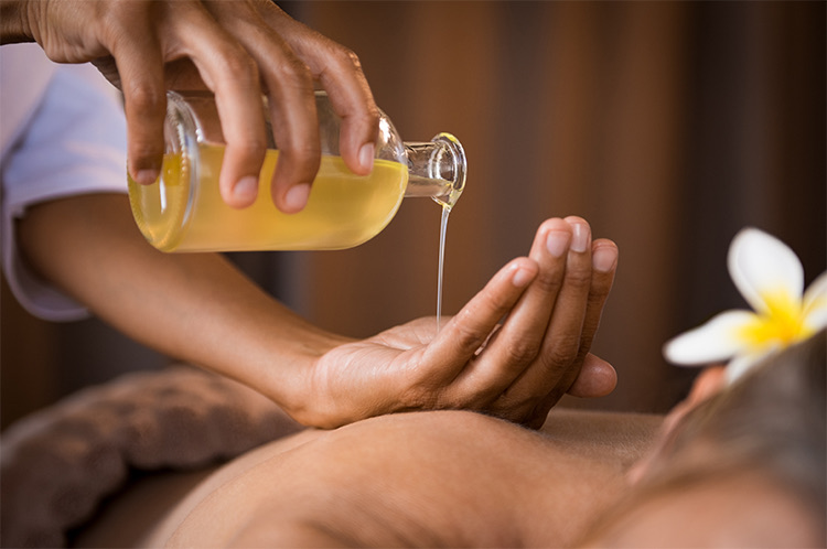 yellow spa oil being poured onto a hand
