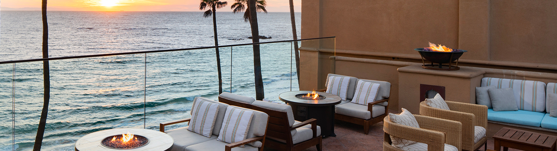 patio next to the ocean with seating and firepits