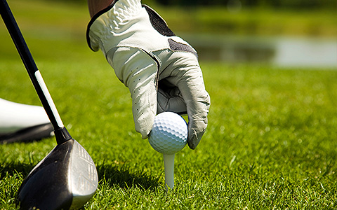 man teeing up golf ball