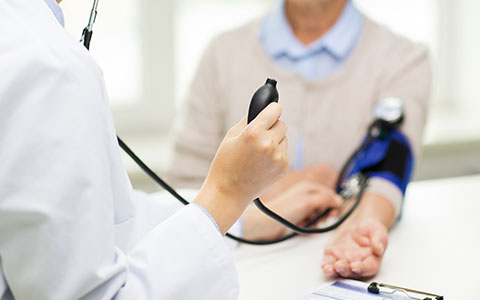 woman taking man's blood pressure