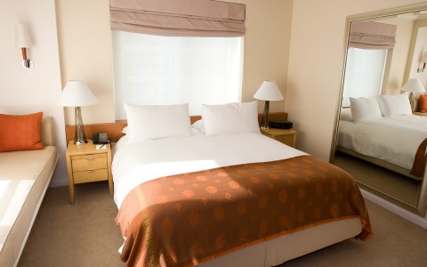 deluxe room with a large mirror next to the queen bed