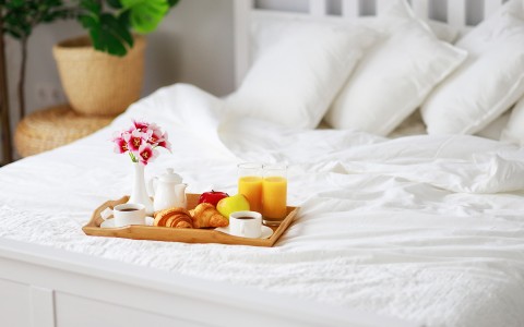 breakfast served on a tray and placed on the bed