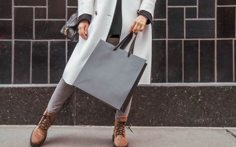 woman nicely-dressed holding a black shopping bag