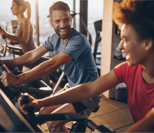 people doing exercise on a static bike
