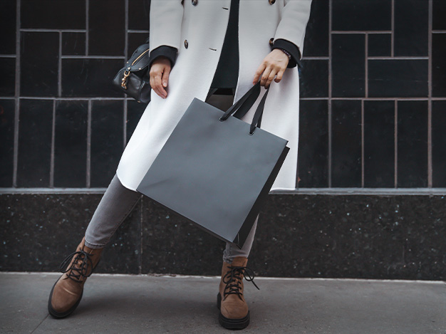 low angle of a lady well-dressed with a shopping bag