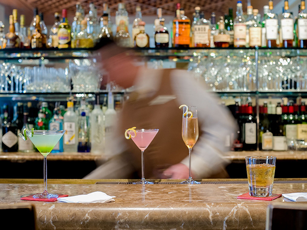 blurred image of the barista making cocktail drinks at the bar