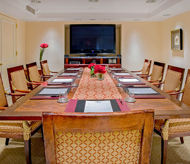 elegant boardroom with wooden furniture and a large tv screen at the front of the room