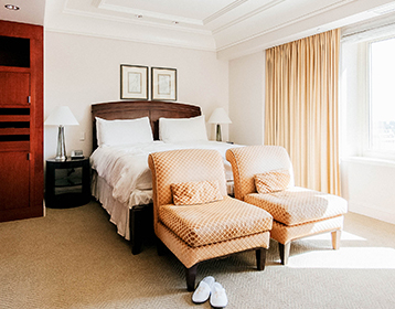 side angle of the bed next to the window within the suite