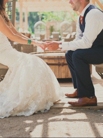 bride and groom holding hands in chairs