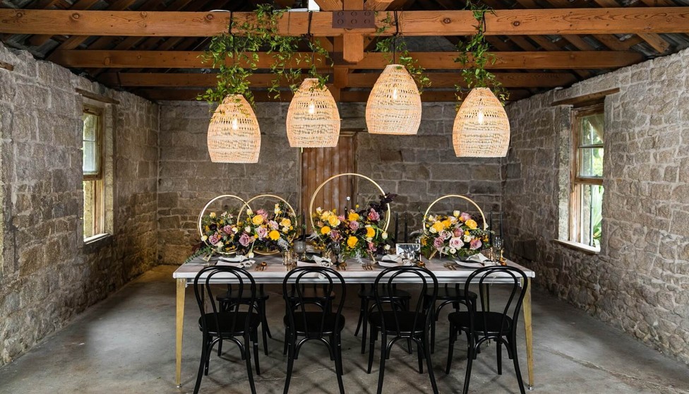 decorative light pendants overtop a table decorated with florals