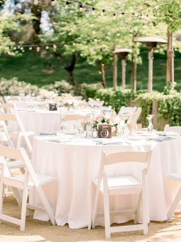 outdoor wedding reception tables with white chairs and table cloths