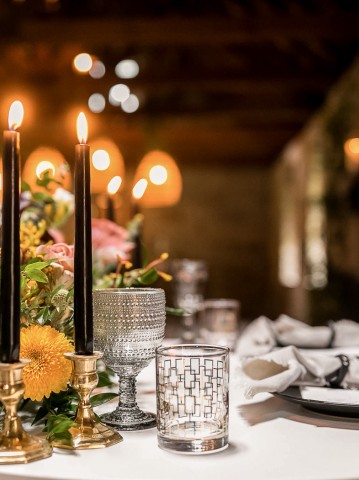 close up of flowers and candles on a wedding reception table indoors