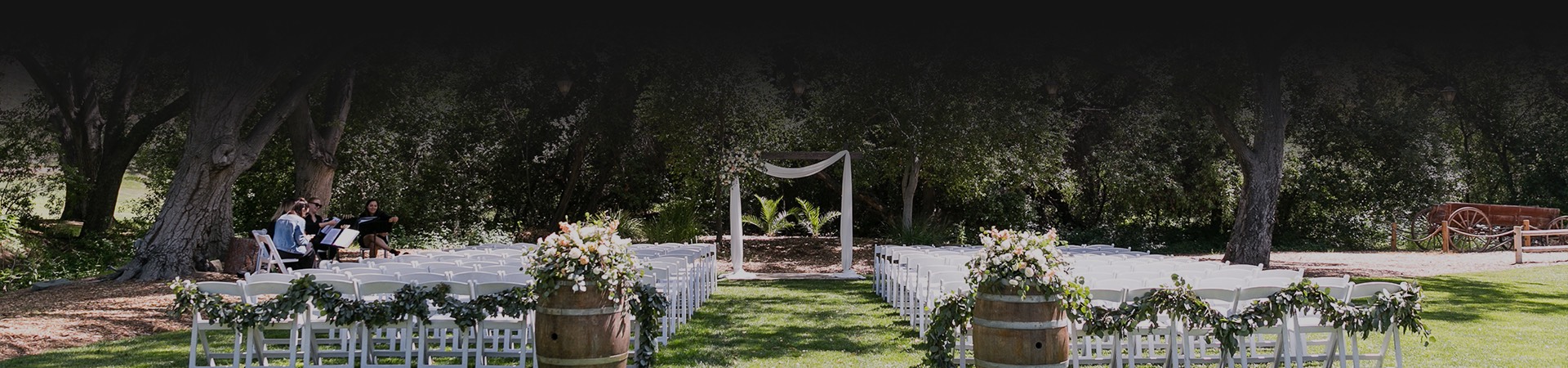 wedding ceremony with white chairs set up outside