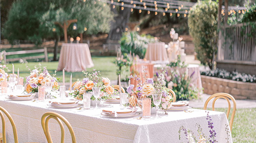 decorative table scape outdoors with floral centerpieces