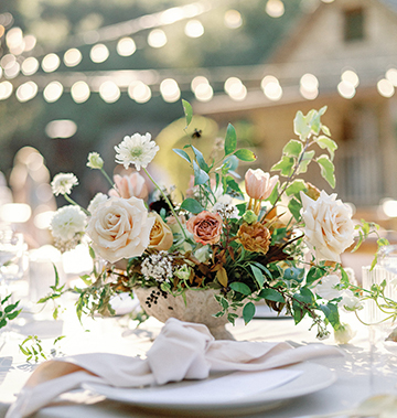 wedding table decorated with utensils, plates, and floral arrangements