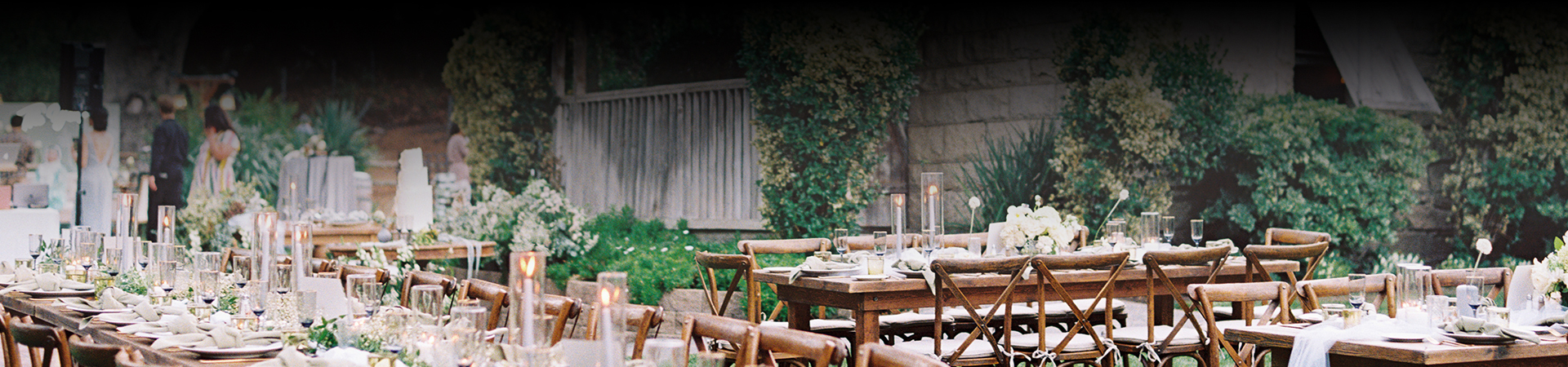 wedding reception tables set up outside with white tablecloths