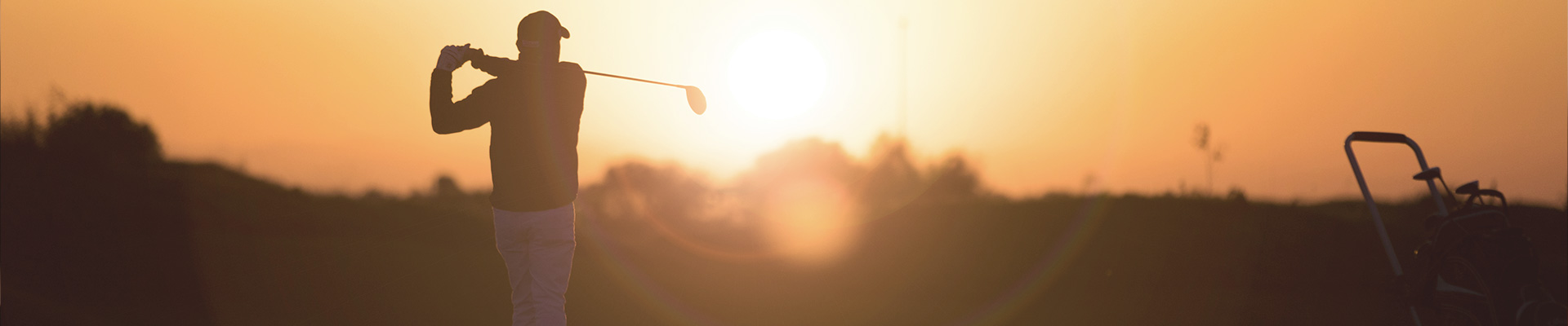 man playing golf in a sunset