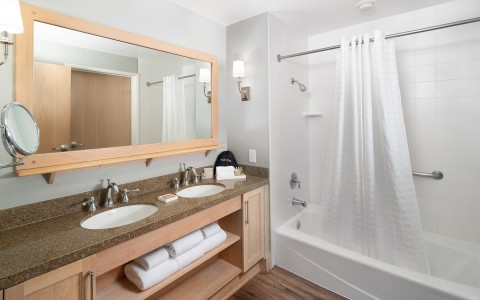 large bathroom with double sinks and shower/tub combo