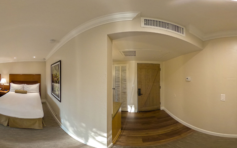 wide angle view of room entryway and spacious queen bed