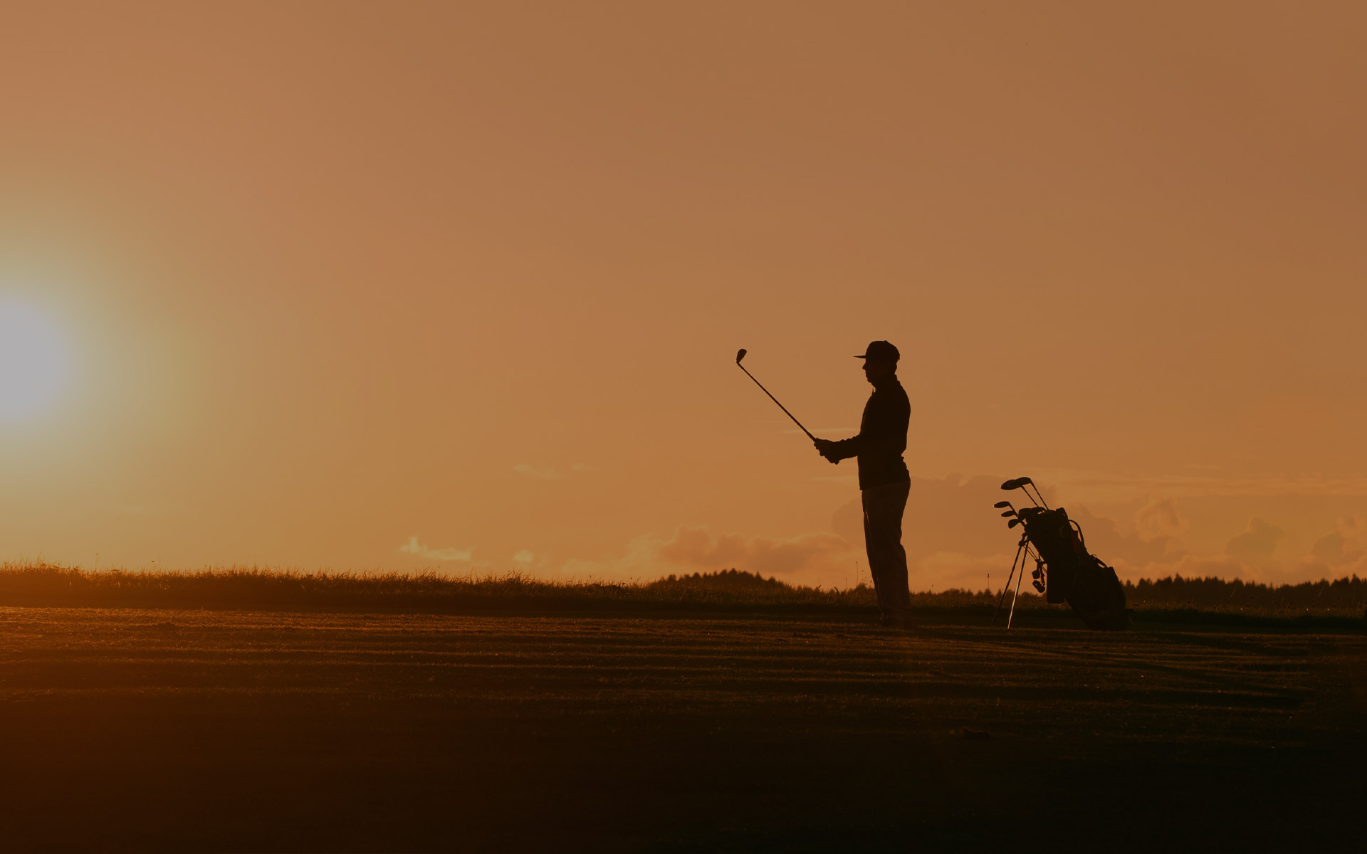 silhouette of a person playing golf