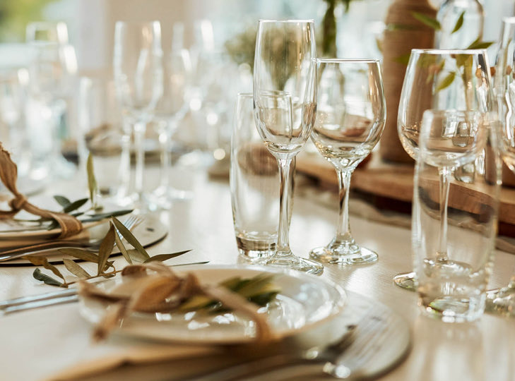 close up image of table settings with white plates and glasses 