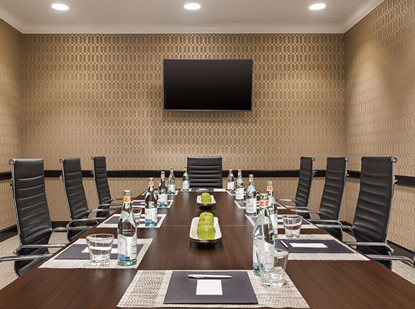 meeting space with a long meeting table black chairs and a tv