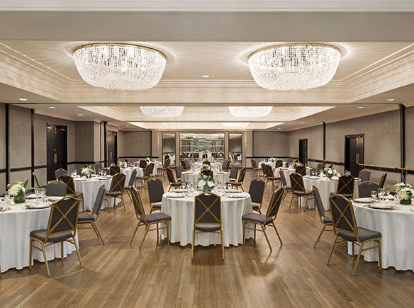 crystal ballroom with beautiful light fixtures and round tables with white table cloths