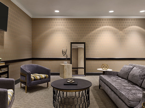 event room with a grey couch and two grey chairs with a black coffee table