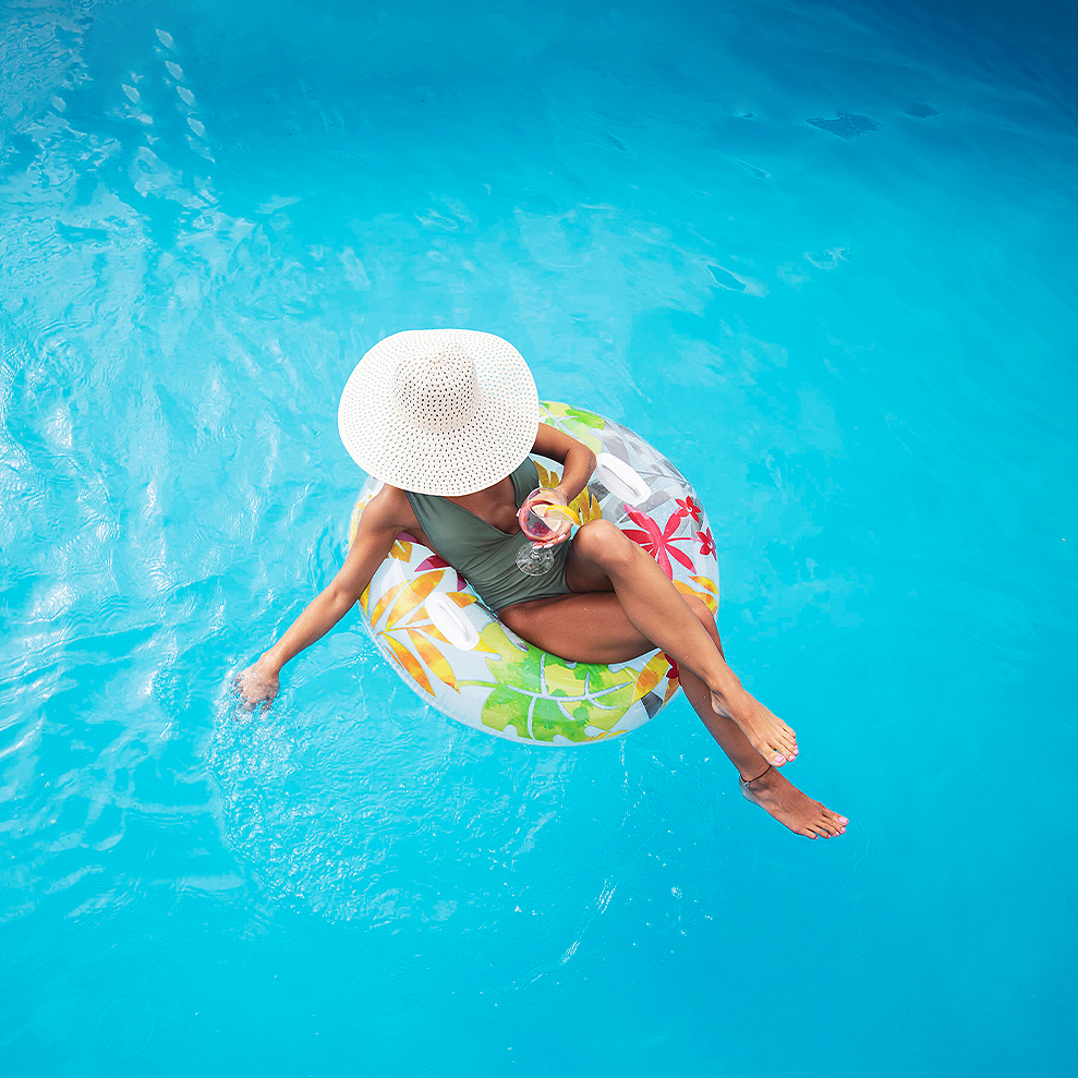 woman on a float on the pool wearing a hat