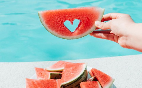 watermelon by the pool with a heart shape cut into it
