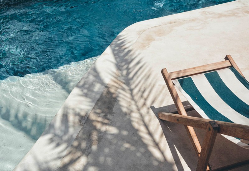 exterior image of the pool with a palm tree shadow