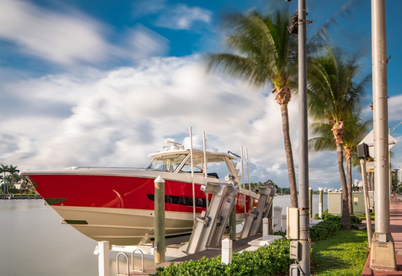 a red boat docked next to palm trees outside on a sunny day