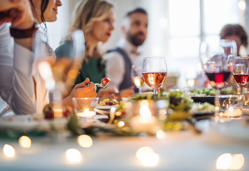 people sitting at a table that is set with wine glasses and food on the table