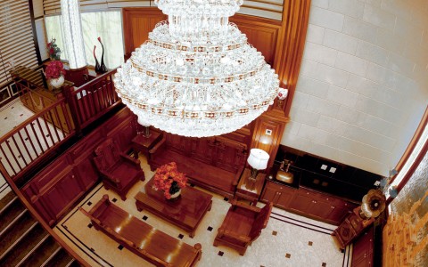 lobby and chandelier with wooden benches and chairs 