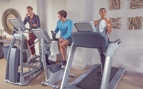 three people doing cardio at the hotel gym